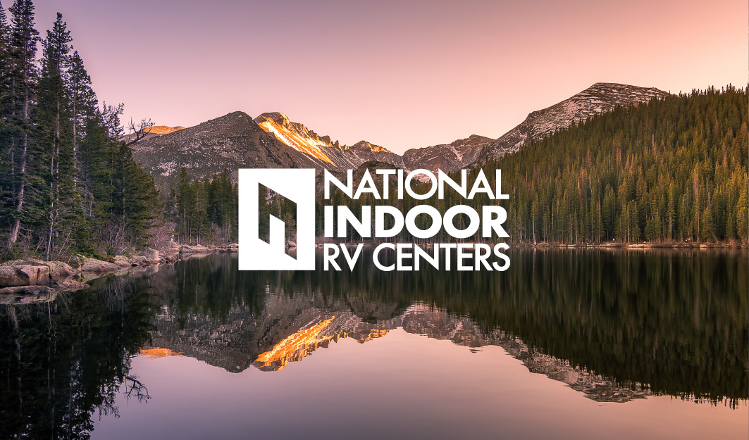 NIRVC Logo Floating Above Glassy Lake Surrounded by Trees in the Mountains