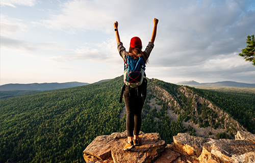 Woman at Top of Mountain, Arms up in Celebration